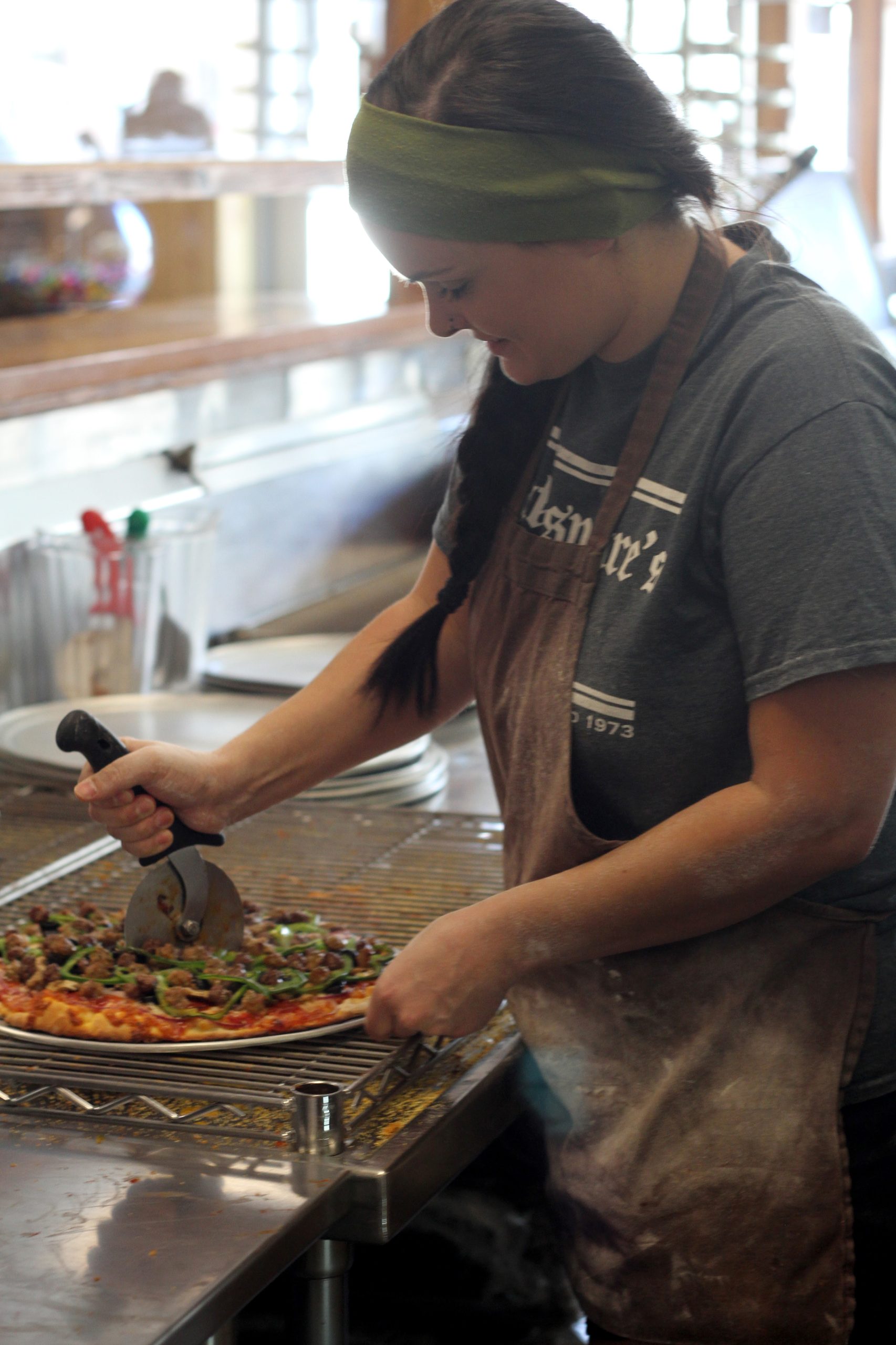 Cutting a fresh pizza with toppings.