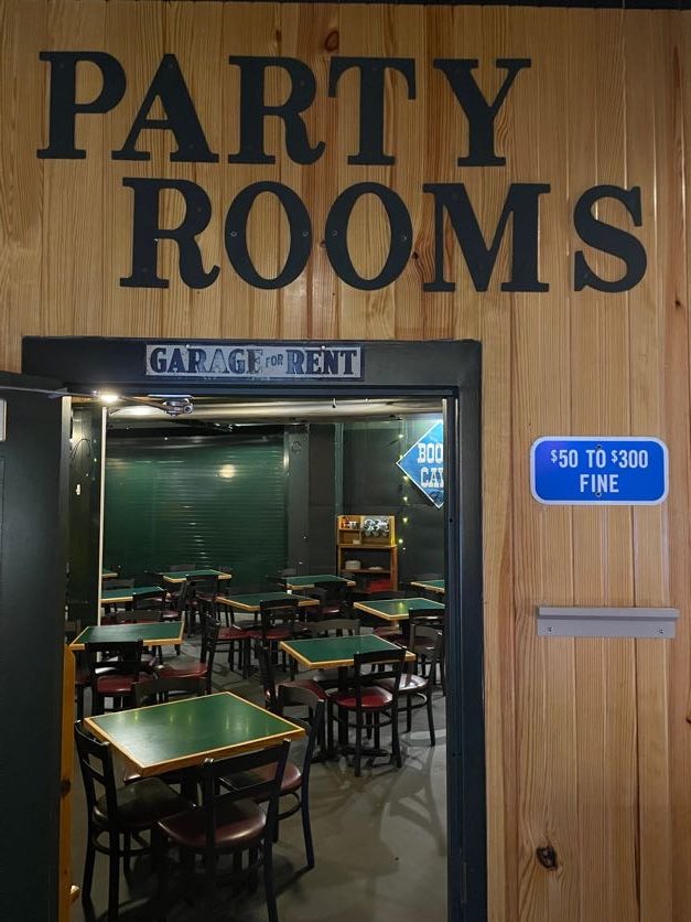 Looking into a room with square tables with a sign that says party rooms.